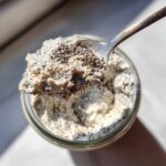 Close-up overhead shot of a spoonful of creamy coconut chia pudding showing visible chia seeds.