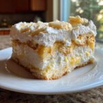 A generous slice of layered banana pudding featuring vanilla wafers, creamy filling, and whipped topping.