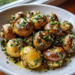 Close-up of whole, sautéed garlic butter mushrooms glistening in sauce and topped with fresh parsley.