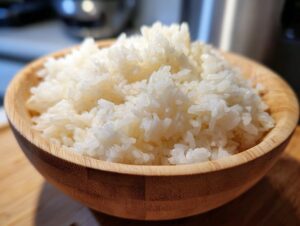 Close-up of fluffy, perfectly cooked sushi rice served in a light wooden bowl.