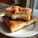Two stacked slices of sopapilla cheesecake showing the creamy filling and cinnamon sugar topping.